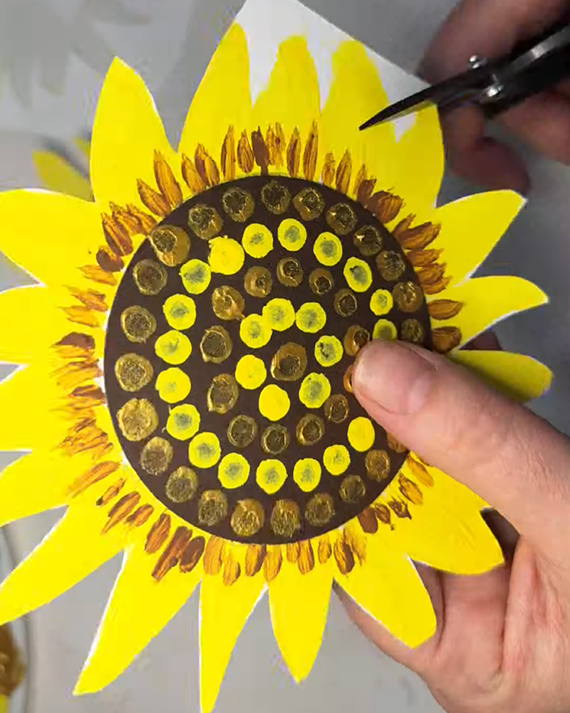 Cutting out the finished sunflower artwork.