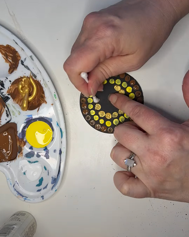 Painting dots on the sunflower center with a cotton swab.